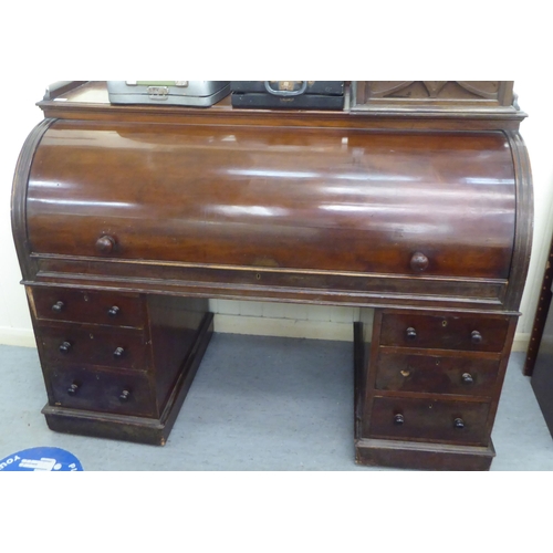 29 - A late Victorian mahogany cylinder desk, enclosing a part fitted interior, over two, three drawer pe... 