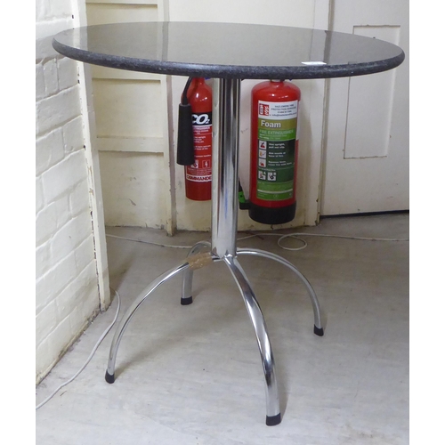 301 - A modern chromium plated steel pedestal table with a black stone top, raised on a quadruped base&nbs... 