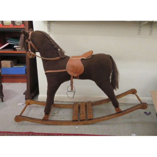 31 - A Mamas & Papas brown fabric covered rocking horse, on a splayed beech plinth  39