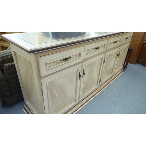 321 - A modern cream painted MDF sideboard with four drawers and four doors, on a plinth  37