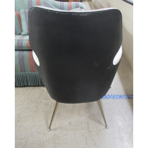 37 - A mid 20thC design office reception chair, upholstered in black and white hide, raised on tapered, m... 