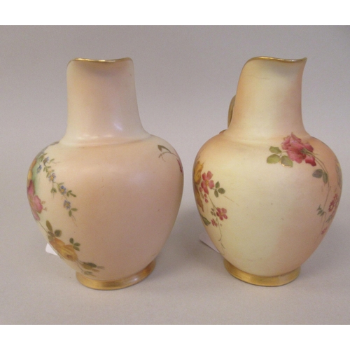 69 - A pair of Royal Worcester blush ivory glazed and gilded china flatback jugs, decorated with mixed fl... 