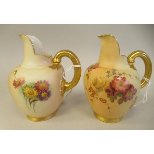 69 - A pair of Royal Worcester blush ivory glazed and gilded china flatback jugs, decorated with mixed fl... 