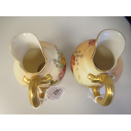 69 - A pair of Royal Worcester blush ivory glazed and gilded china flatback jugs, decorated with mixed fl... 