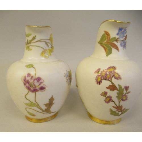 74 - A pair of Royal Worcester blush ivory glazed and gilded china flatback jugs, decorated with mixed fl... 