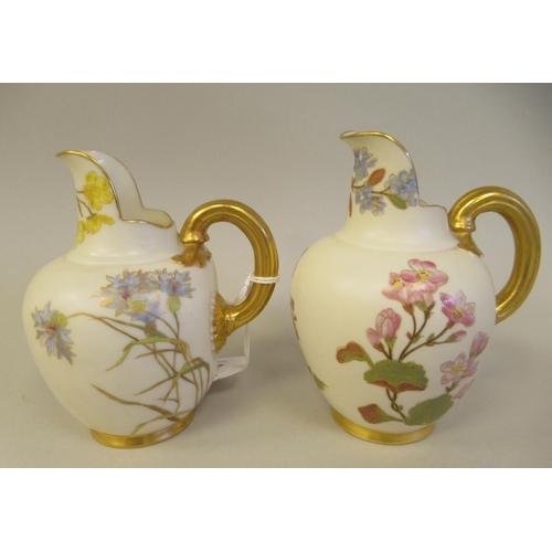 74 - A pair of Royal Worcester blush ivory glazed and gilded china flatback jugs, decorated with mixed fl... 