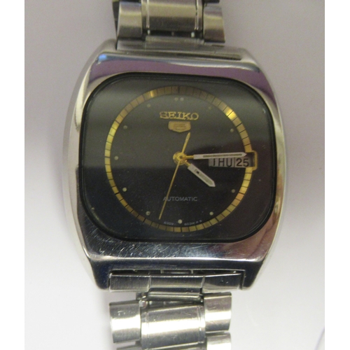 82 - A vintage Seiko 5 automatic, stainless steel cased bracelet wristwatch, faced by a black and gilt ba... 