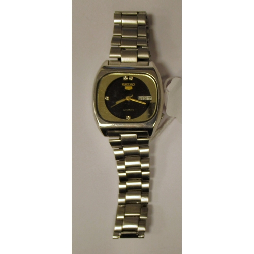 90 - A vintage Seiko 5 automatic stainless steel cased bracelet watch, faced by a black dial with a day a... 