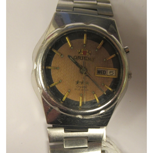 91 - A vintage Orient Crystal automatic stainless steel cased bracelet watch, faced by a black and gilt b... 