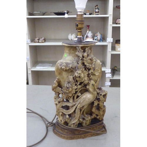 A 20thC Chinese soapstone table lamp with metal mounts, ornately carved