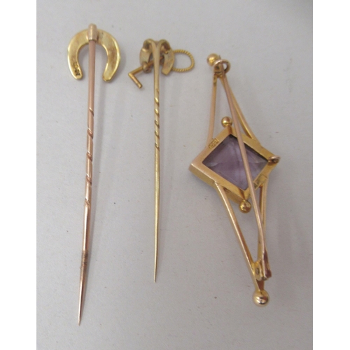 163 - Three 15ct gold stickpins, viz. one of geometric form, set with an amethyst coloured stone; and two ... 