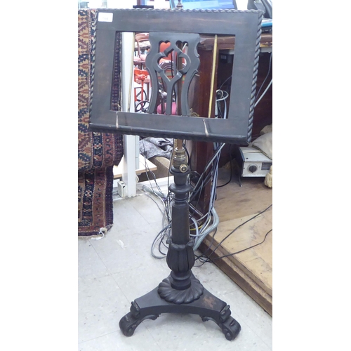 164 - A Victorian style dark stained carved softwood music stand with a height adjustable stem, elevated o... 