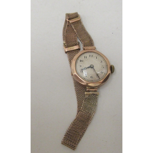 185 - A ladies 9ct gold cased wristwatch, on a wide flexible bracelet, faced by an Arabic dial 