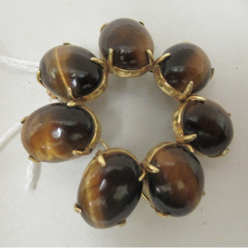 186 - A 14ct gold brooch, set with seven cabochon tigers eye stones