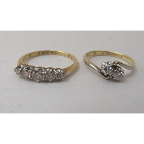 211 - An 18ct gold claw set, five stone diamond ring; and an 18ct gold crossover set, five stone diamond r... 