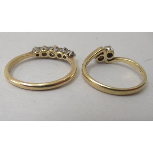 211 - An 18ct gold claw set, five stone diamond ring; and an 18ct gold crossover set, five stone diamond r... 