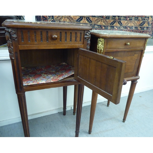 222 - Two similar early 20thC French mahogany bedside pot cupboards with marble tops, each with a shallow ... 