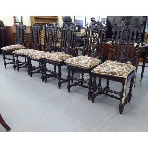 230 - A set of six early 20thC stained and carved oak framed dining chairs with trailing vine splats and b... 