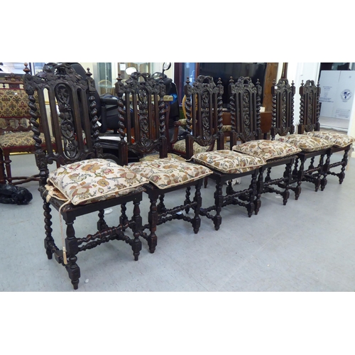 230 - A set of six early 20thC stained and carved oak framed dining chairs with trailing vine splats and b... 