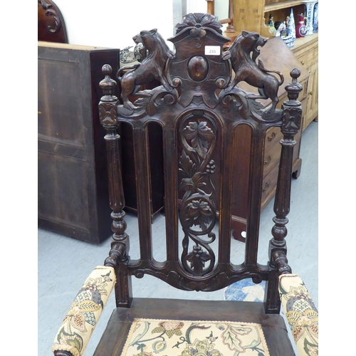 235 - A late 19th/early 20thC stained and carved oak throne chair with a decorative armorial crest and fru... 