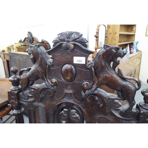 235 - A late 19th/early 20thC stained and carved oak throne chair with a decorative armorial crest and fru... 