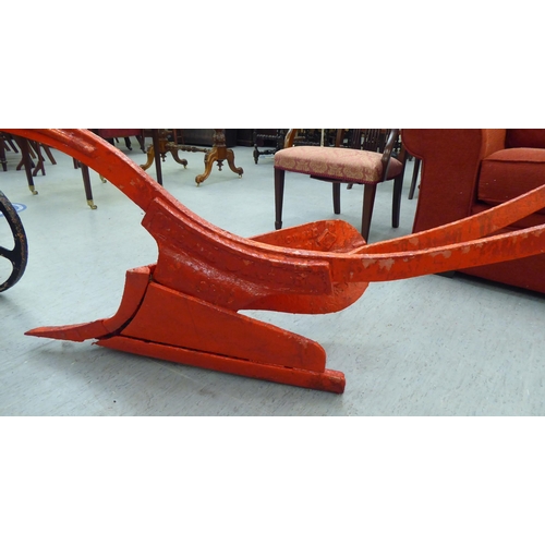 249 - An early 20thC Howard red painted steel horse drawn plough, on iron spoked wheels  120