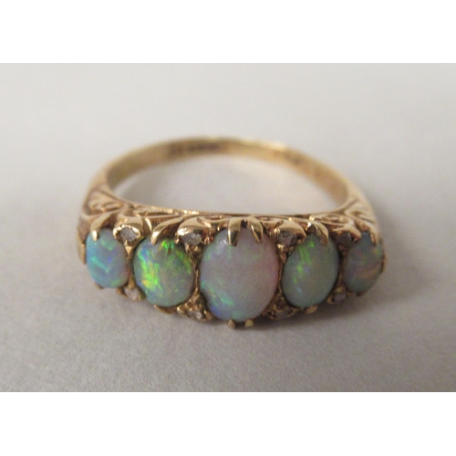 25 - An 18ct gold opal and diamond ring, in a scrolled setting 