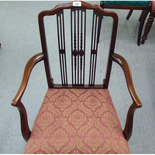 250 - A lady's Edwardian mahogany framed chair with decoratively carved splats and open arms, the braided,... 