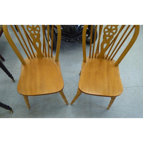 255 - A pair of modern light stained beech framed, hoop and wheelback Windsor breakfast room chairs with s... 