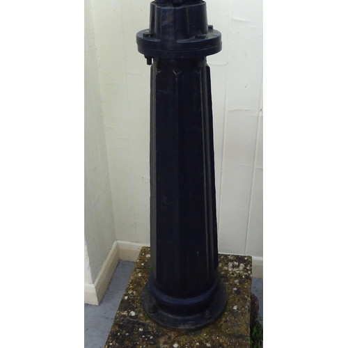 258 - A Terpo black painted cast iron water pump head, secured to a concrete plinth  65