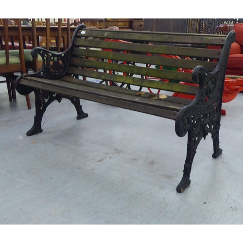 259 - A 20thC Victorian design garden bench seat with black painted cast iron ends and teak slats  50