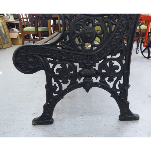 259 - A 20thC Victorian design garden bench seat with black painted cast iron ends and teak slats  50