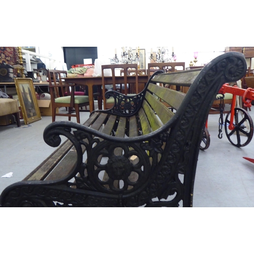 259 - A 20thC Victorian design garden bench seat with black painted cast iron ends and teak slats  50