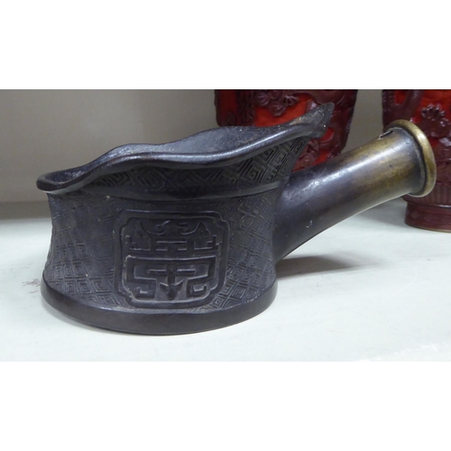 277 - 20thC Oriental collectables: to include two similar patinated bronze silk irons with cast ornament