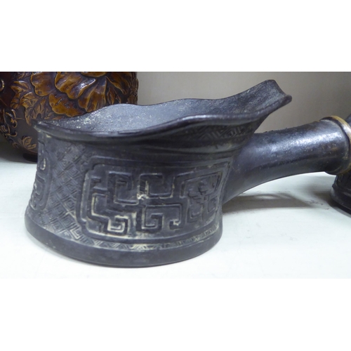 277 - 20thC Oriental collectables: to include two similar patinated bronze silk irons with cast ornament