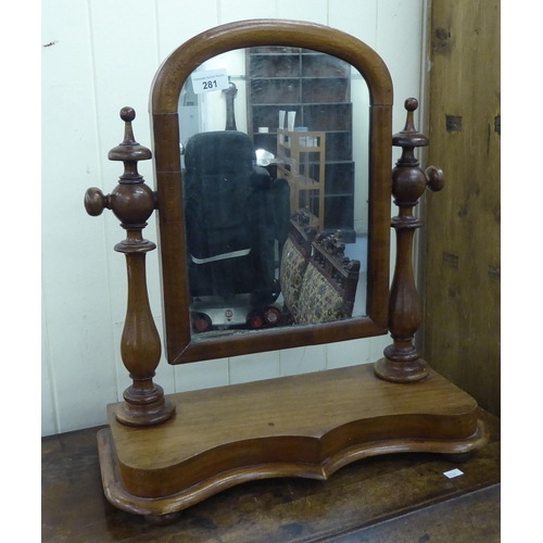 281 - A late Victorian toilet mirror, the arched plate set in a mahogany frame, pivoting on ring turned ho... 