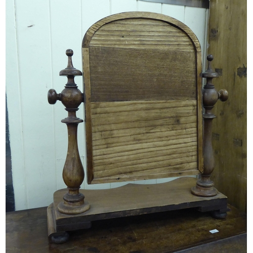 281 - A late Victorian toilet mirror, the arched plate set in a mahogany frame, pivoting on ring turned ho... 