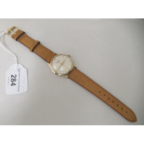 284 - A 9ct gold cased Longines manual wristwatch, faced by an Arabic dial, on a tan leather strap