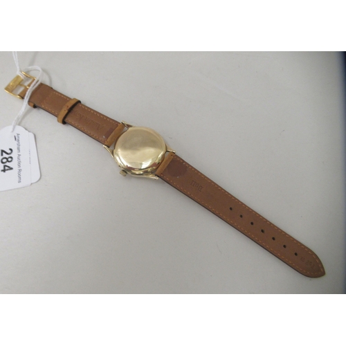 284 - A 9ct gold cased Longines manual wristwatch, faced by an Arabic dial, on a tan leather strap