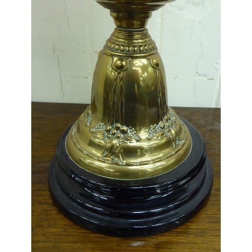 286 - A late Victorian brass oil lamp, the reservoir on an embossed cone shape pedestal and ceramic base  ... 