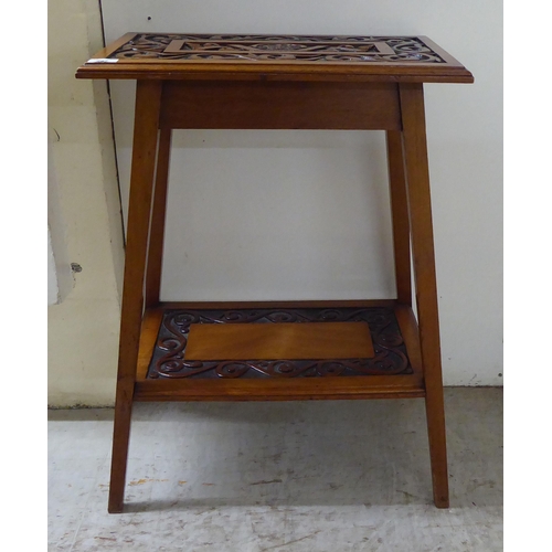 297 - A late 19thC mahogany two tier occasional table with foliate scrolled and ribbon carved ornament, ra... 