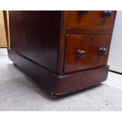 298 - A late Victorian mahogany nine drawer, twin pedestal desk with bun handles and a green fabric scribe... 