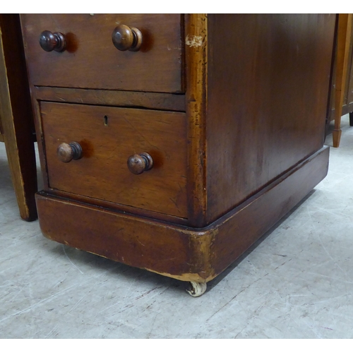 298 - A late Victorian mahogany nine drawer, twin pedestal desk with bun handles and a green fabric scribe... 