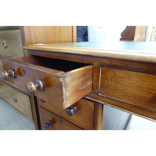 298 - A late Victorian mahogany nine drawer, twin pedestal desk with bun handles and a green fabric scribe... 