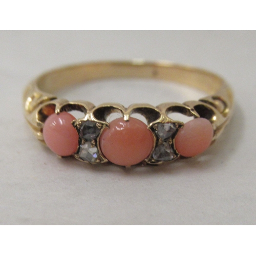 305 - A yellow metal ring, set with diamonds and coral