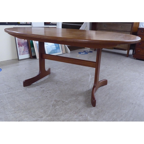 308 - A modern teak extending dining table, the oval top incorporating an integrated additional leaf, rais... 