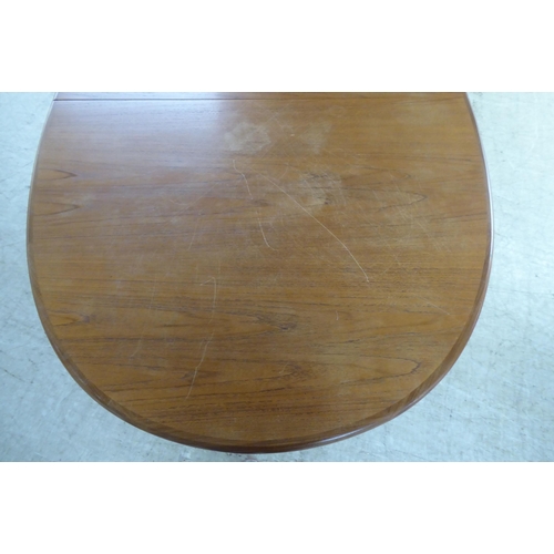 308 - A modern teak extending dining table, the oval top incorporating an integrated additional leaf, rais... 