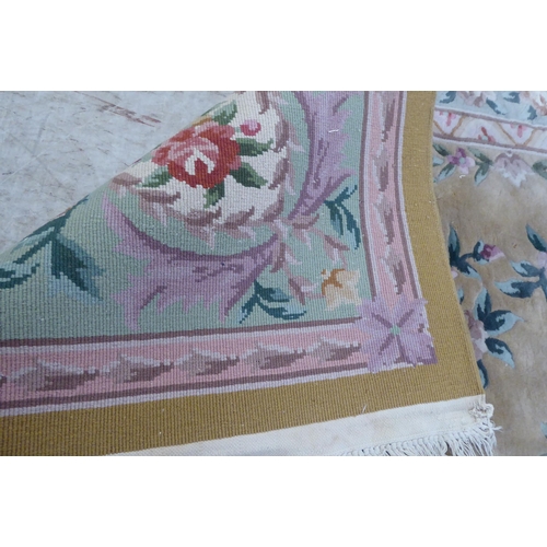 317 - A modern cotton carpet, decorated in pastel colours with floral designs  120