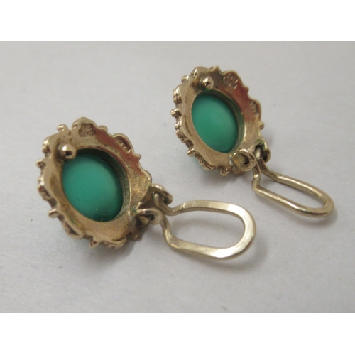 328 - A pair of 9ct gold clip earrings, each set with green stone