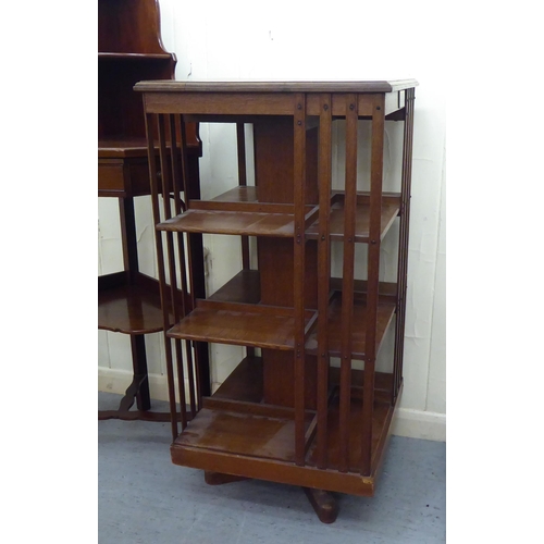 41 - An Edwardian oak revolving bookcase with slatted sides, on platform feet  43